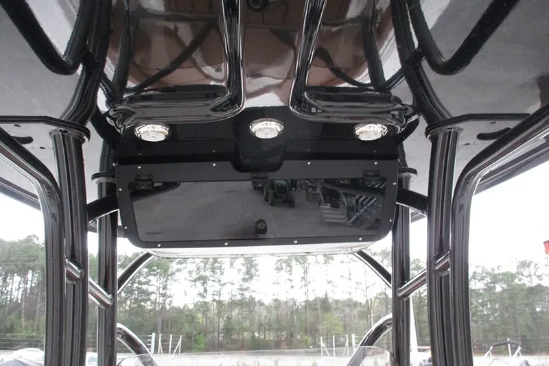 Slide: The Image of 2025 Pioneer 222 Islander boat interior with sleek black overhead console and lighting. - 32