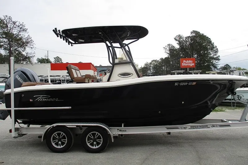 Slide: The Image of 2025 Pioneer 222 Islander boat on trailer, featuring sleek black design and Yamaha engine. - 7