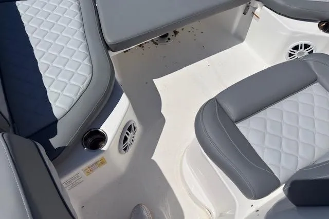 Slide: The Image of 2024 NauticStar 211 Hybrid boat interior with gray quilted seating and cup holders. - 10