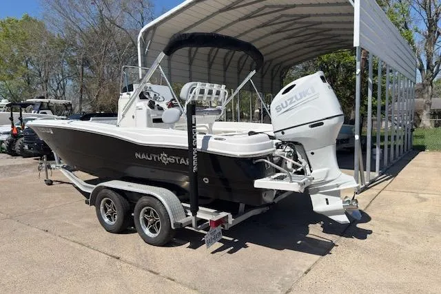 Slide: The Image of 2024 NauticStar 211 Hybrid boat with Suzuki engine on trailer under canopy. - 3