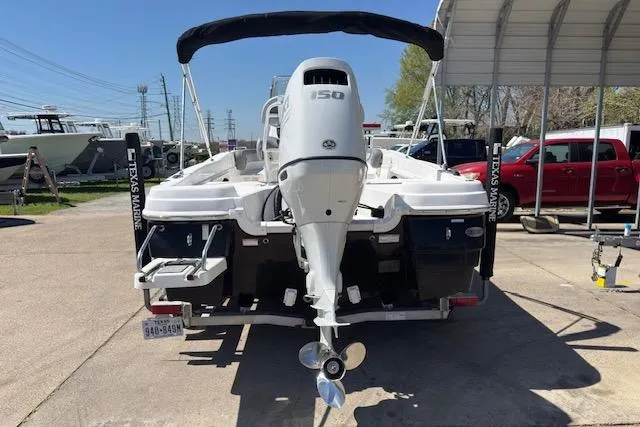 Slide: The Image of 2024 NauticStar 211 Hybrid boat with Yamaha 150 outboard motor, parked at a marina. - 4