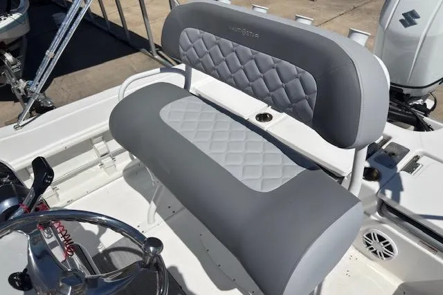 Slide: The Image of 2024 NauticStar 211 Hybrid boat seat with gray quilted upholstery and steering wheel. - 7