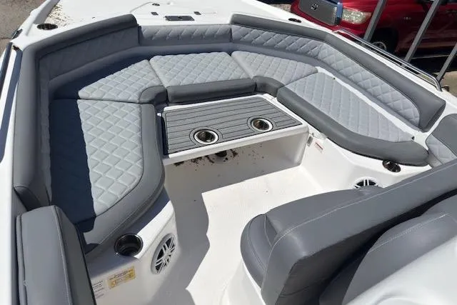 Slide: The Image of 2024 NauticStar 211 Hybrid boat interior with gray cushioned seating and cup holders. - 9