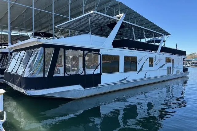 The Image of 1999 Sumerset 18x82 houseboat docked in a marina under a covered structure. - 0