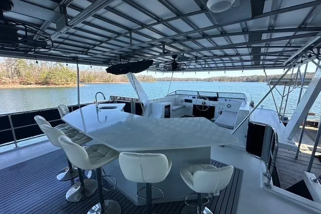 Slide: The Image of Luxurious 1999 Sumerset 18x82 houseboat with modern bar seating and scenic lake view. - 14