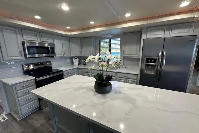 Slide: The Image of Modern kitchen in 1999 Sumerset 18x82 houseboat with sleek appliances and marble island. - 5