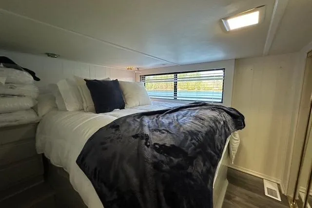 Slide: The Image of Cozy bedroom interior in 1999 Sumerset 18x82 houseboat with plush bedding and natural light. - 8