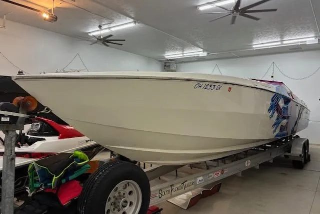 The Image of 1984 Cigarette 35' Cafe Racer boat on trailer in garage setting. - 1