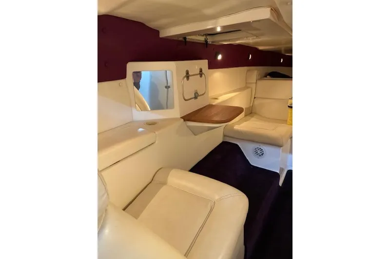 Slide: The Image of Interior of a 1984 Cigarette 35' Cafe Racer boat with beige seating and wooden table. - 8