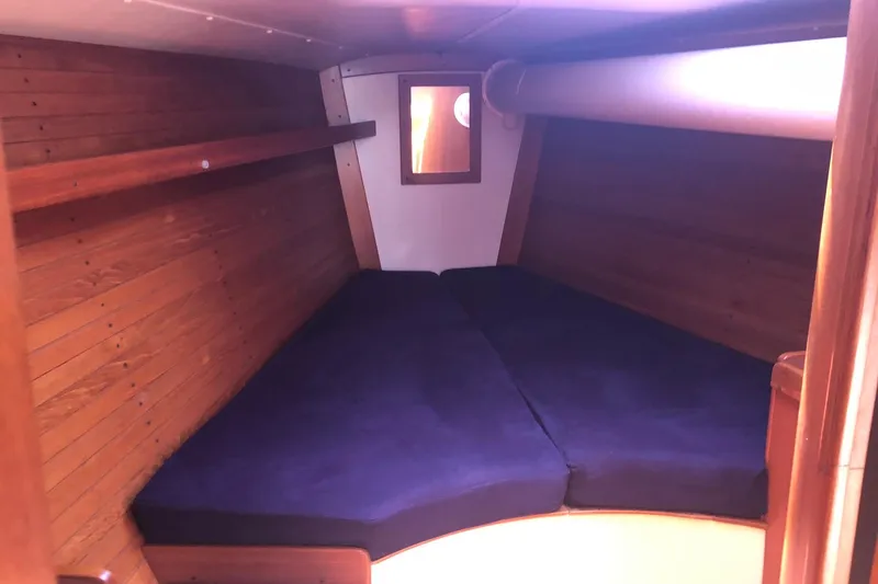 Slide: The Image of Interior cabin of 2004 J Boats J/133 with wooden walls and blue cushions. - 10
