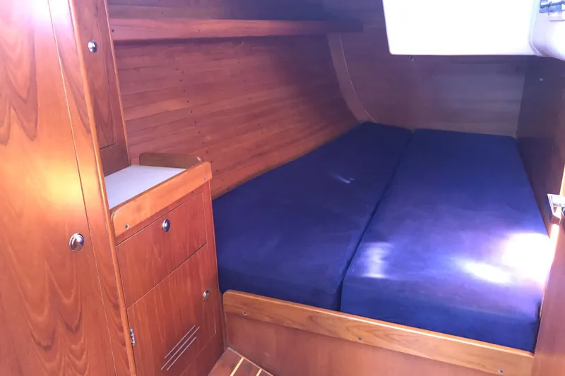 Slide: The Image of Cozy cabin interior of 2004 J Boats J/133 with wooden finish and blue cushions. - 12