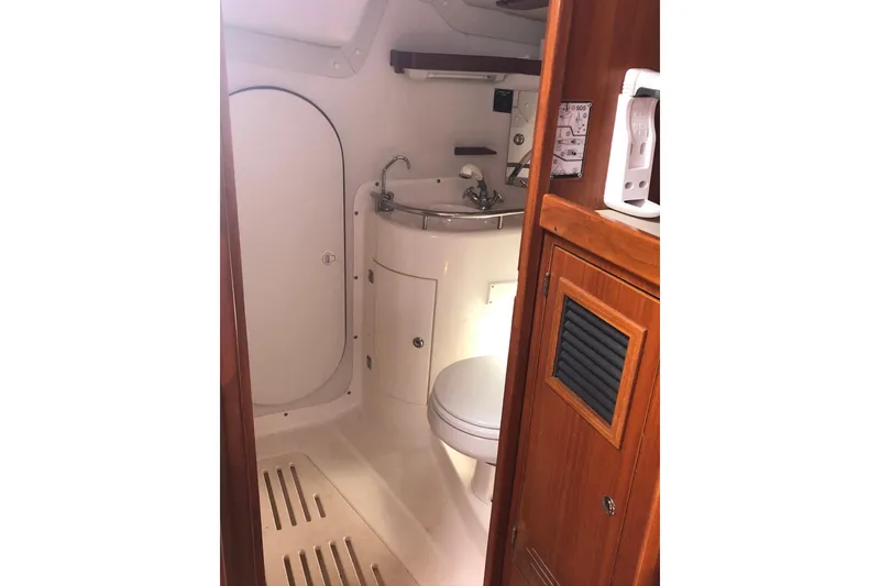 Slide: The Image of 2004 J Boats J/133 yacht bathroom with sink, toilet, and wooden cabinetry. - 20