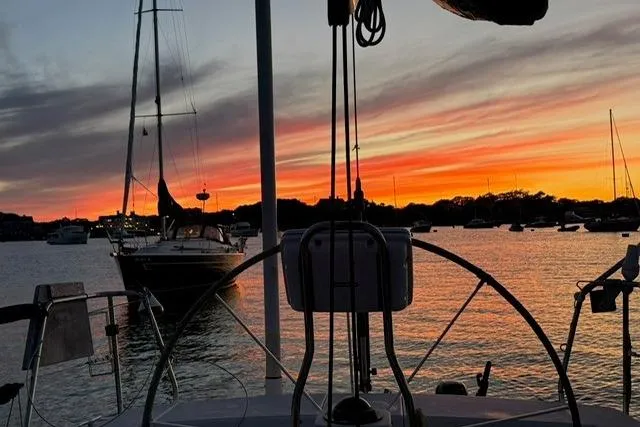 Slide: The Image of Sailboat silhouette at sunset, featuring a 2004 J Boats J/133 model. - 25