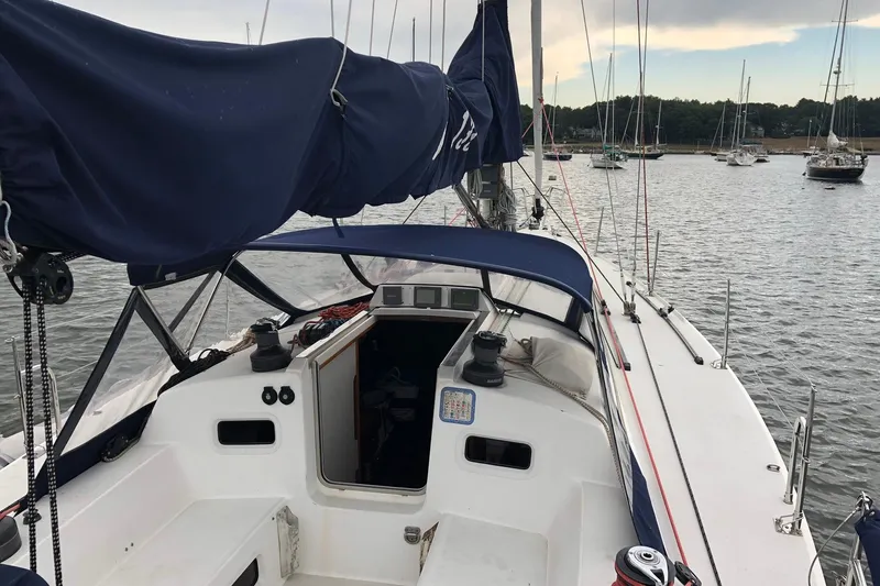 Slide: The Image of Sailboat J/133 from 2004 docked, featuring a spacious cockpit and blue sail cover. - 3