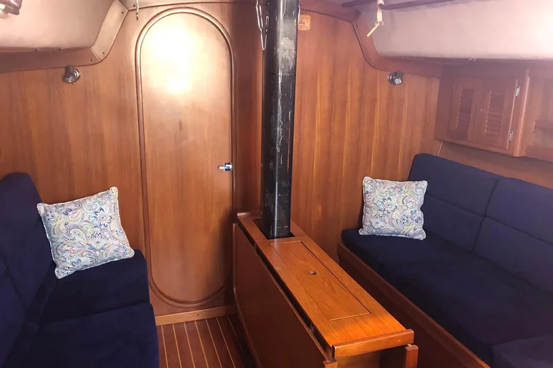 Slide: The Image of Interior of 2004 J Boats J/133 sailboat with wooden paneling and blue seating. - 7
