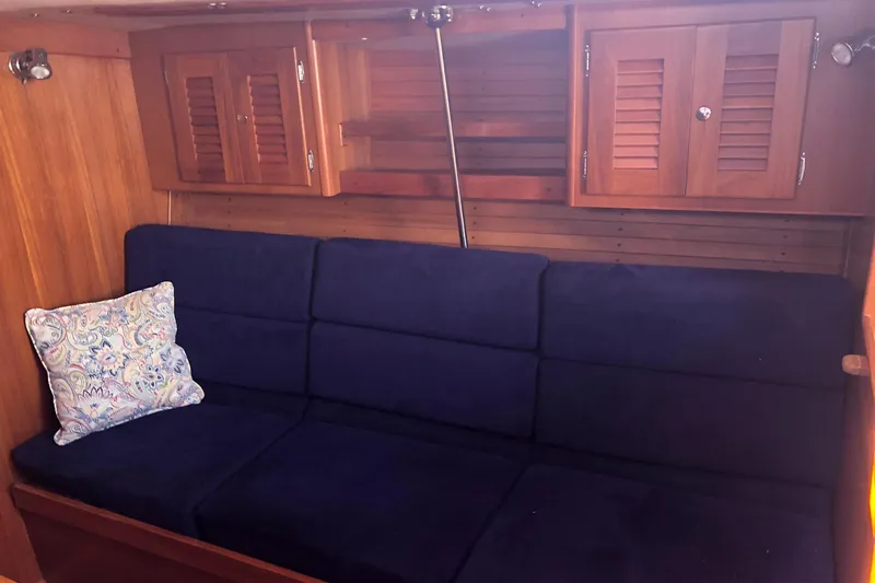 Slide: The Image of Interior of 2004 J Boats J/133 with blue sofa and wooden cabinets. - 9