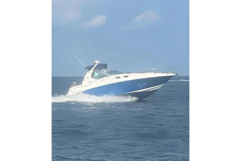 Slide: The Image of 2005 Sea Ray Sundancer 320 cruising on open water under a clear blue sky. - 17