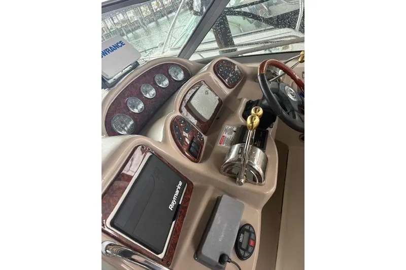 Slide: The Image of Helm of 2005 Sea Ray Sundancer 320 with Raymarine navigation system and wood-accented controls. - 31
