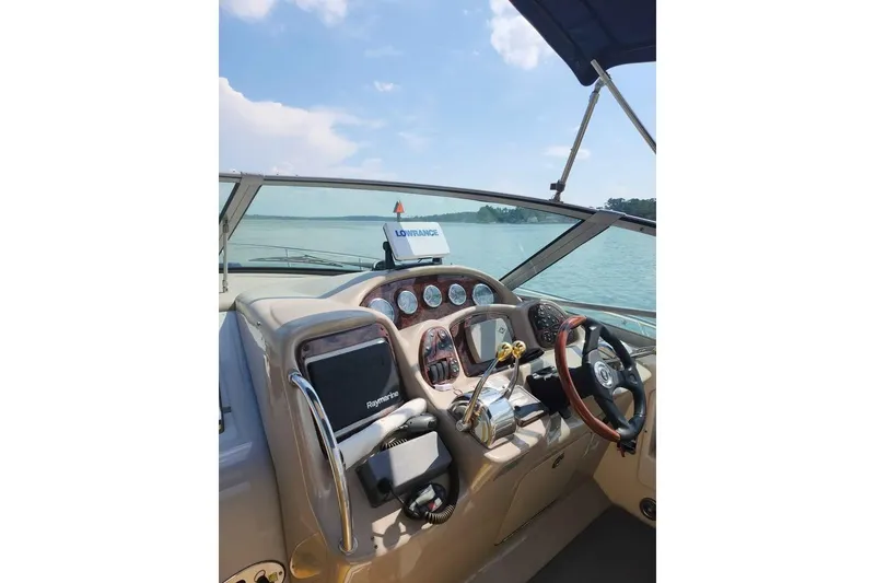 Slide: The Image of 2005 Sea Ray Sundancer 320 helm with navigation equipment, steering wheel, and water view. - 7