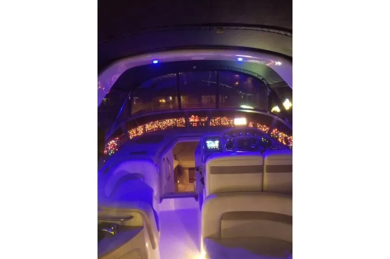 Slide: The Image of 2005 Sea Ray Sundancer 320 interior with ambient blue lighting and festive decorations. - 8