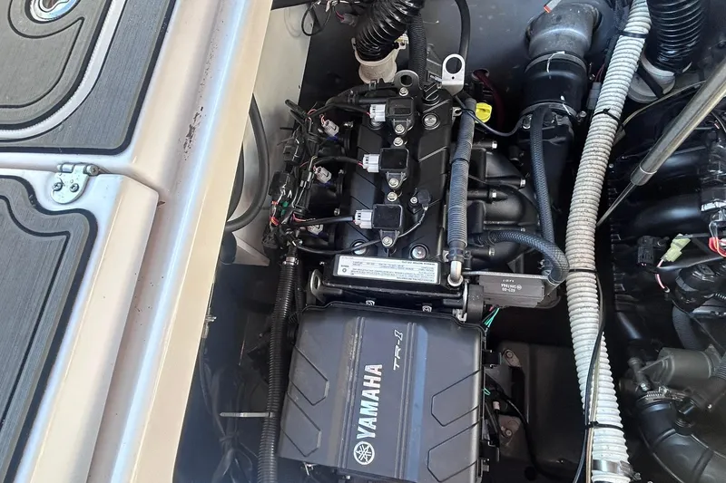 Slide: The Image of Engine compartment of a 2019 Yamaha Boats 210 FSH Sport, showcasing mechanical components. - 16