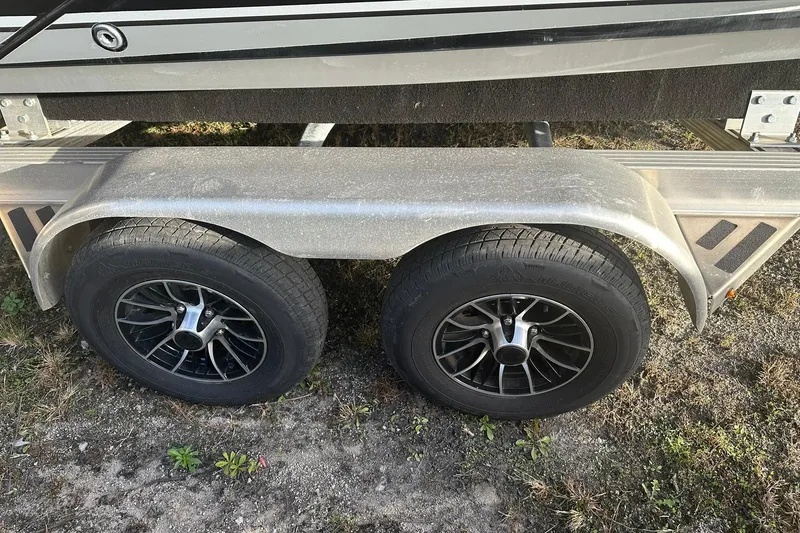 Slide: The Image of Trailer wheels of a 2019 Yamaha Boats 210 FSH Sport on grassy ground. - 25