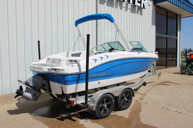 Slide: The Image of 2021 Chaparral 19 SSi Ski & Fish boat on trailer, blue and white exterior. - 24