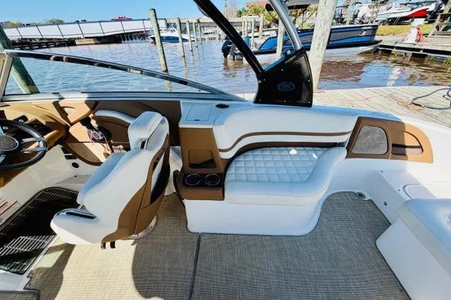 Slide: The Image of 2017 Cobalt R7 boat interior with white and brown seating, docked by the water. - 10