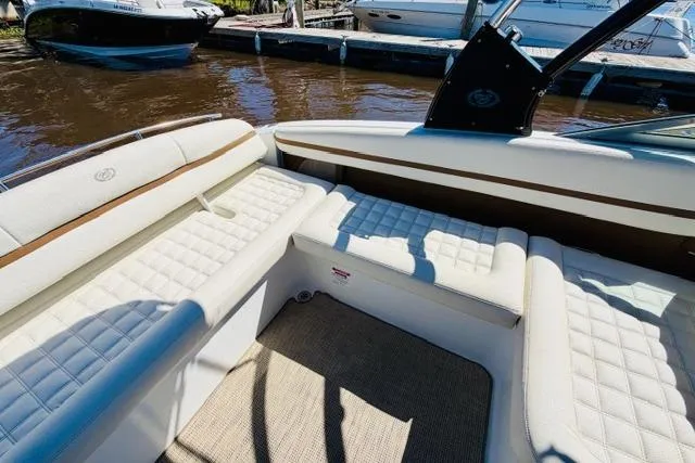 Slide: The Image of 2017 Cobalt R7 boat interior with white cushioned seating at a dock. - 12