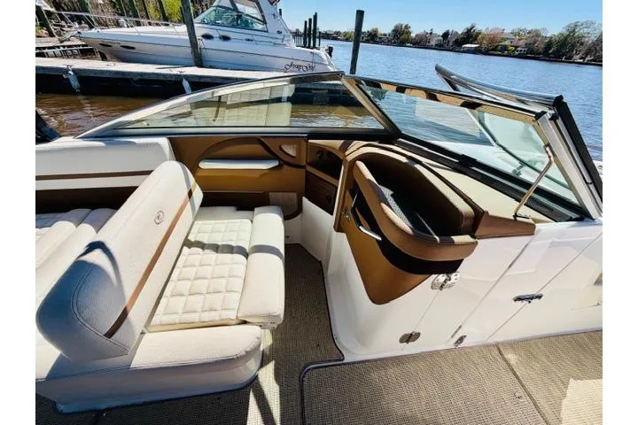 Slide: The Image of 2017 Cobalt R7 boat interior with white and brown seating, docked by the water. - 13