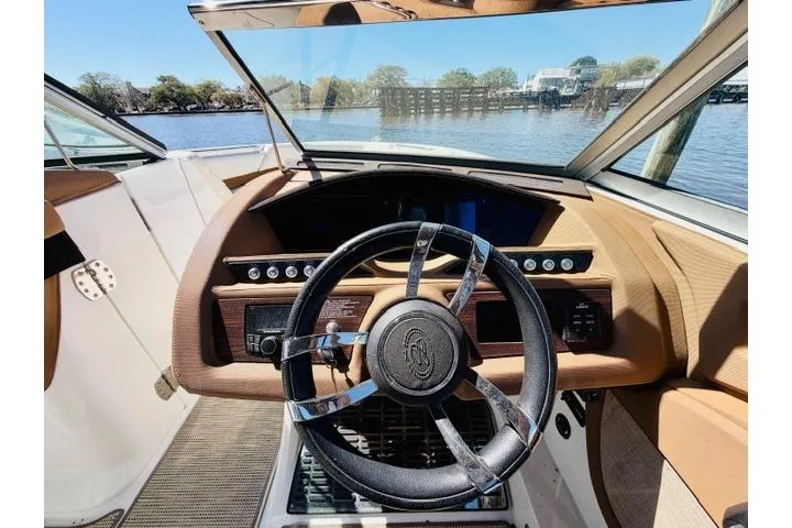 Slide: The Image of 2017 Cobalt R7 boat dashboard with steering wheel, overlooking a scenic waterfront. - 16