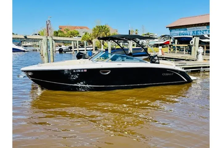 Slide: The Image of 2017 Cobalt R7 boat docked in a marina under clear blue skies. - 2