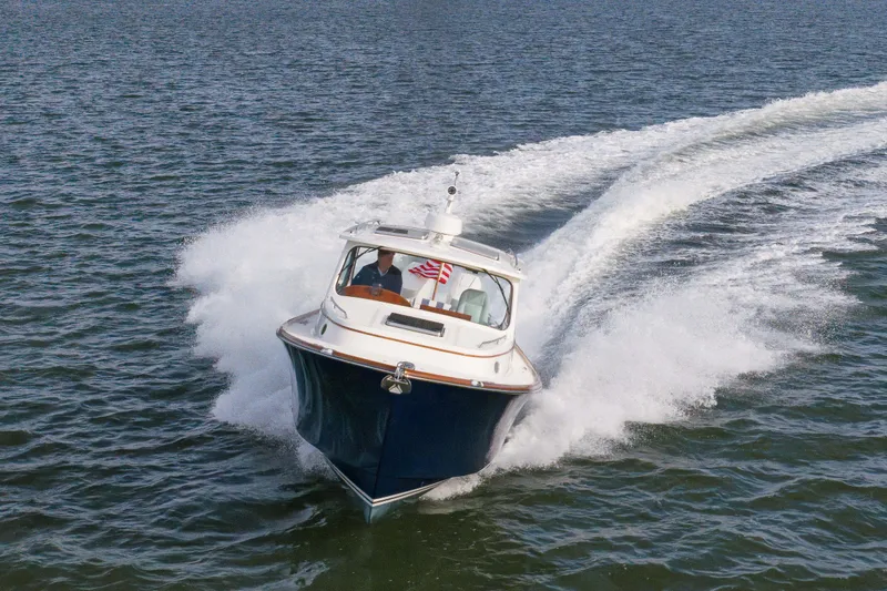 Slide: The Image of 2024 Hinckley 35 boat cruising on open water, creating a dynamic wake. - 10