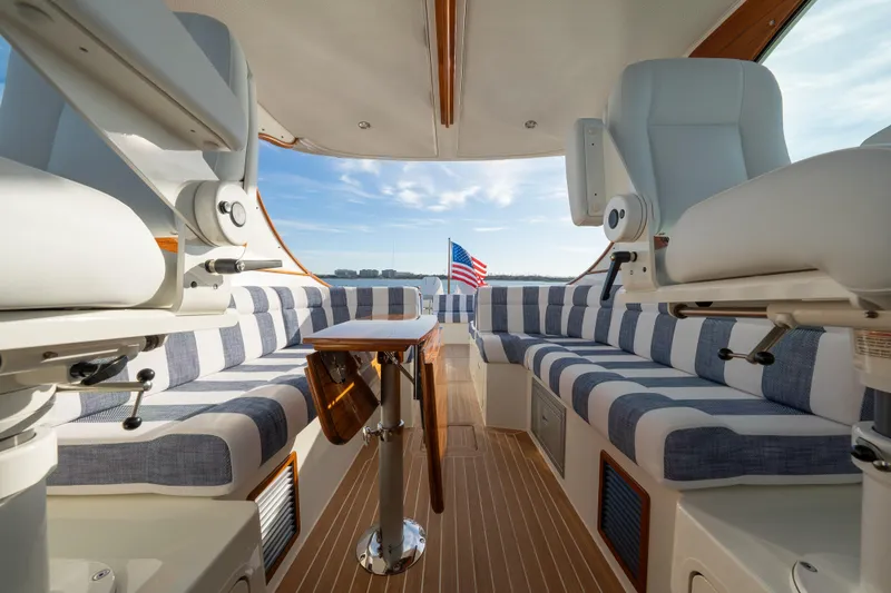 Slide: The Image of 2024 Hinckley 35 yacht interior with striped seating and American flag view. - 18