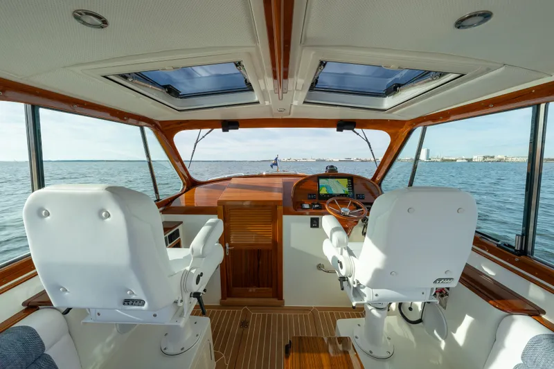 Slide: The Image of Interior view of 2024 Hinckley 35 yacht cockpit with dual white seats and navigation system. - 19