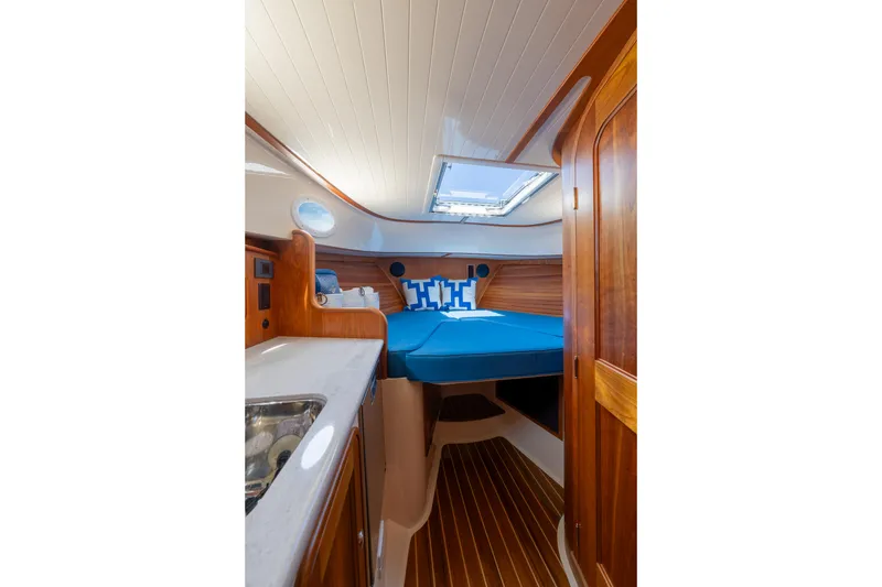Slide: The Image of Luxurious 2024 Hinckley 35 yacht interior with elegant wood finish and cozy sleeping area. - 26