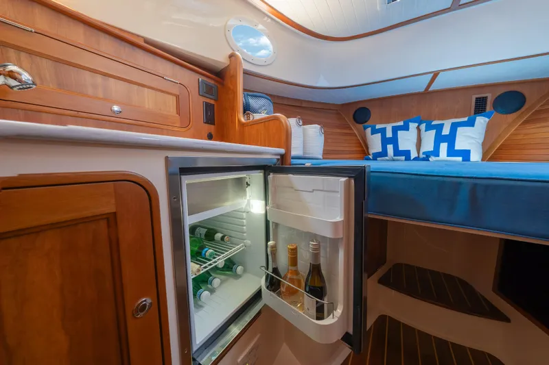 Slide: The Image of Luxurious interior of 2024 Hinckley 35 yacht with open fridge and cozy bedding. - 27