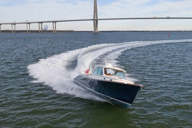 Slide: The Image of 2024 Hinckley 35 boat cruising on water near a large bridge. - 3