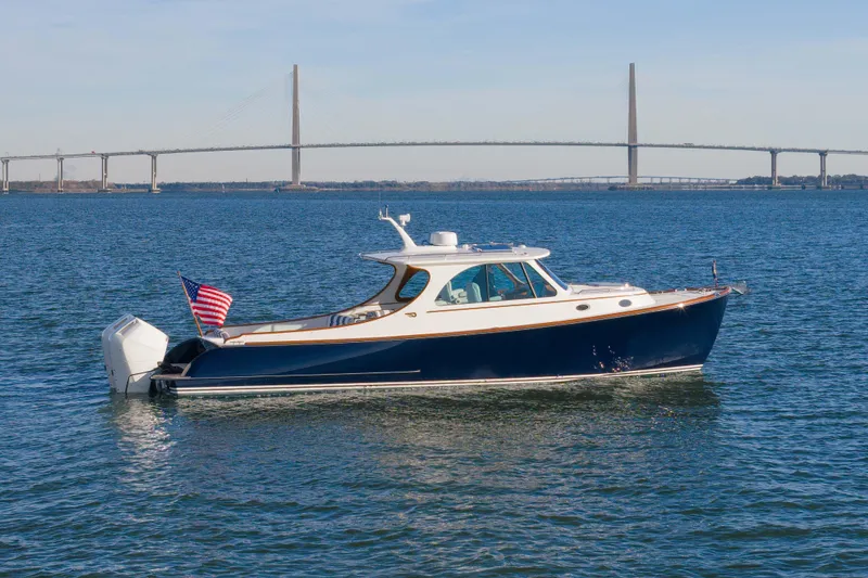 Slide: The Image of 2024 Hinckley 35 yacht cruising on water with bridge in background. - 5