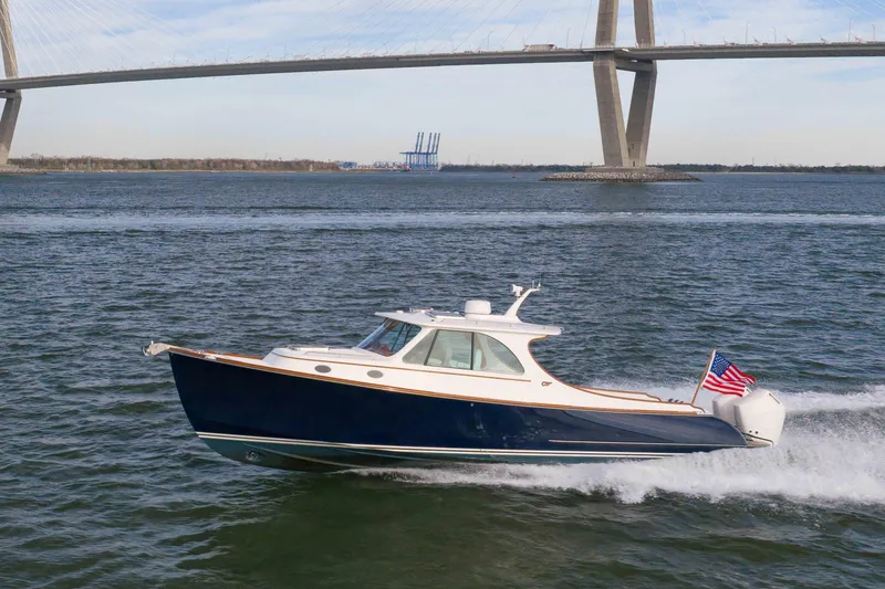 Slide: The Image of 2024 Hinckley 35 boat cruising under a large bridge on a sunny day. - 7