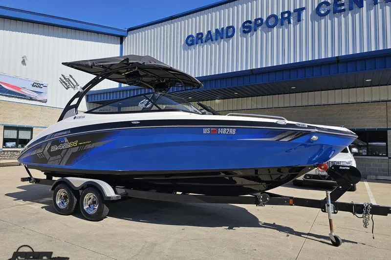 Slide: The Image of 2017 Yamaha Boats 242X E-Series in blue, parked outside Grand Sport Center. - 12