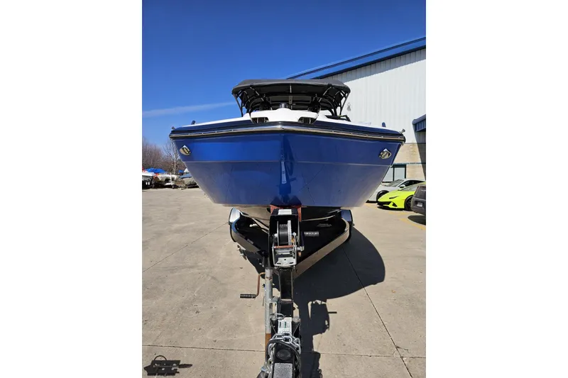 Slide: The Image of 2017 Yamaha Boats 242X E-Series on trailer, blue hull, parked outdoors. - 14