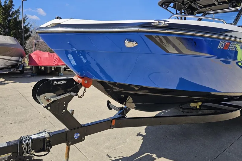 Slide: The Image of 2017 Yamaha Boats 242X E-Series on trailer, blue hull, outdoor setting. - 17