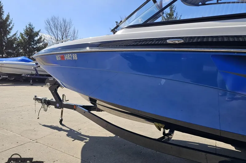 Slide: The Image of 2017 Yamaha Boats 242X E-Series on trailer, blue hull, parked outdoors. - 22