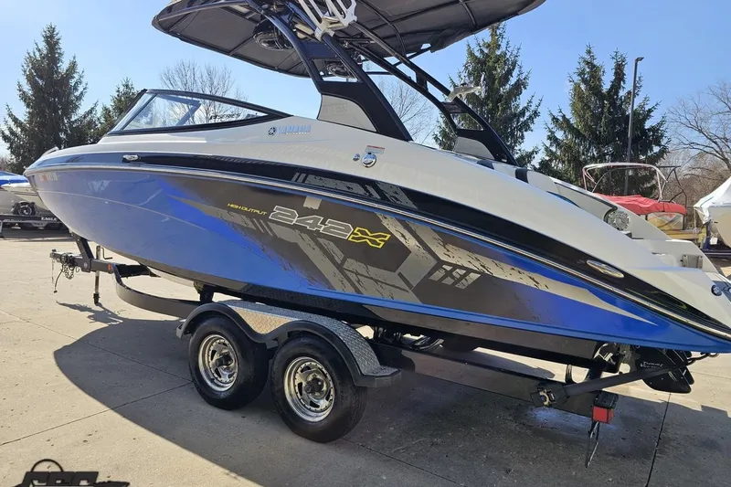 Slide: The Image of 2017 Yamaha Boats 242X E-Series on trailer, blue and white design, parked outdoors. - 26