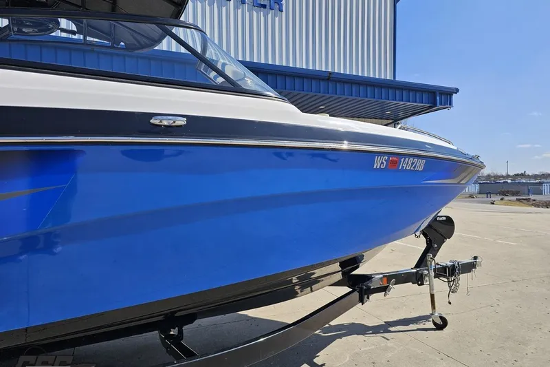 Slide: The Image of Blue 2017 Yamaha Boats 242X E-Series on trailer, parked outdoors. - 4