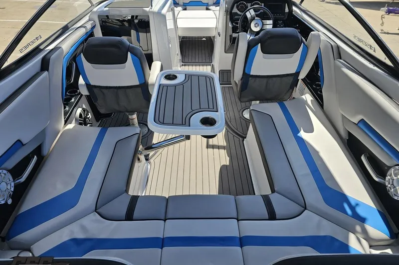 Slide: The Image of Interior of 2017 Yamaha Boats 242X E-Series with blue and white seating and table. - 44