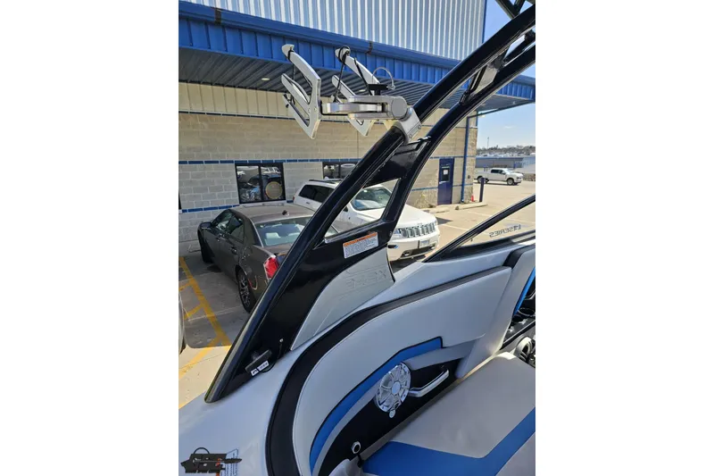 Slide: The Image of 2017 Yamaha Boats 242X E-Series interior with wakeboard rack, parked outside dealership. - 49