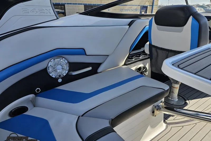 Slide: The Image of 2017 Yamaha Boats 242X E-Series interior with blue and white seating and speaker system. - 56