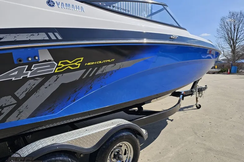 Slide: The Image of 2017 Yamaha Boats 242X E-Series, blue hull, high output graphics, on trailer. - 7